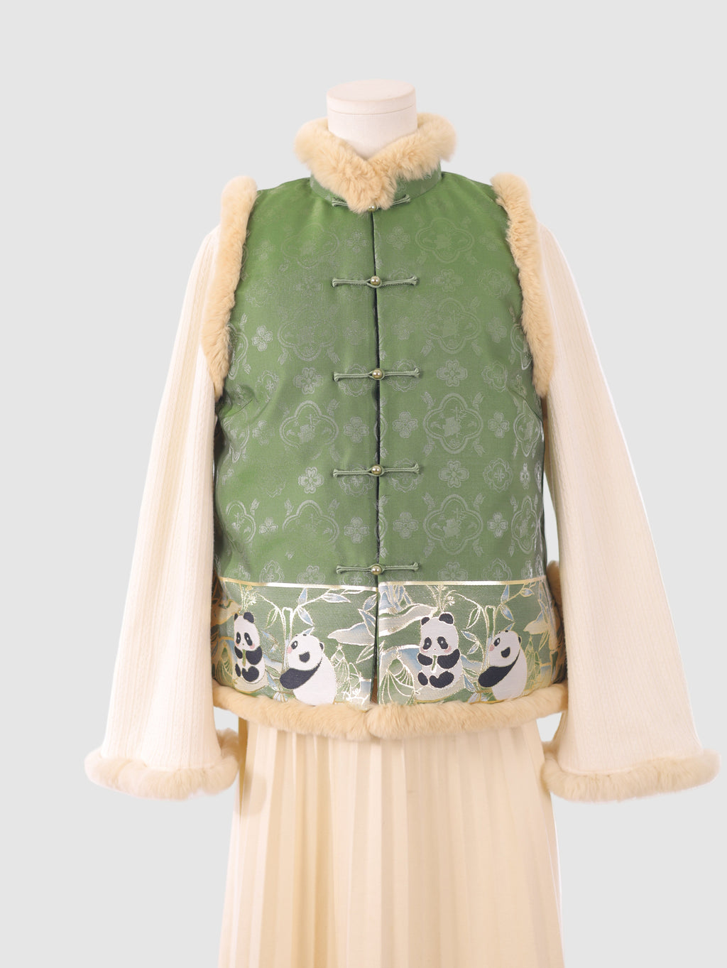Close-up of the green panda-embroidered vest showing knot closures and  fur edging