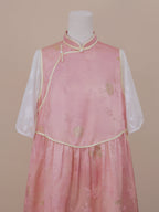 Upper front view of a pink silk handmade qipao with gold floral patterns, pearl frog buttons, and airy sheer white mid-length sleeves.