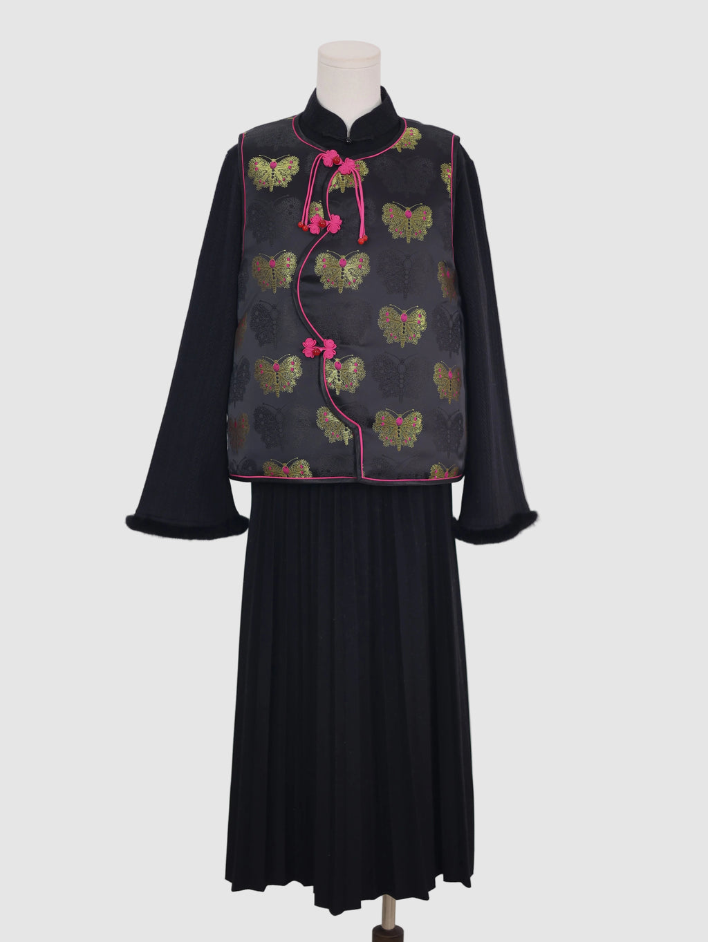 Front view of black butterfly jacquard vest with pink piping and frog button closure