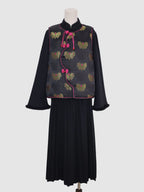 Front view of black butterfly jacquard vest with pink piping and frog button closure