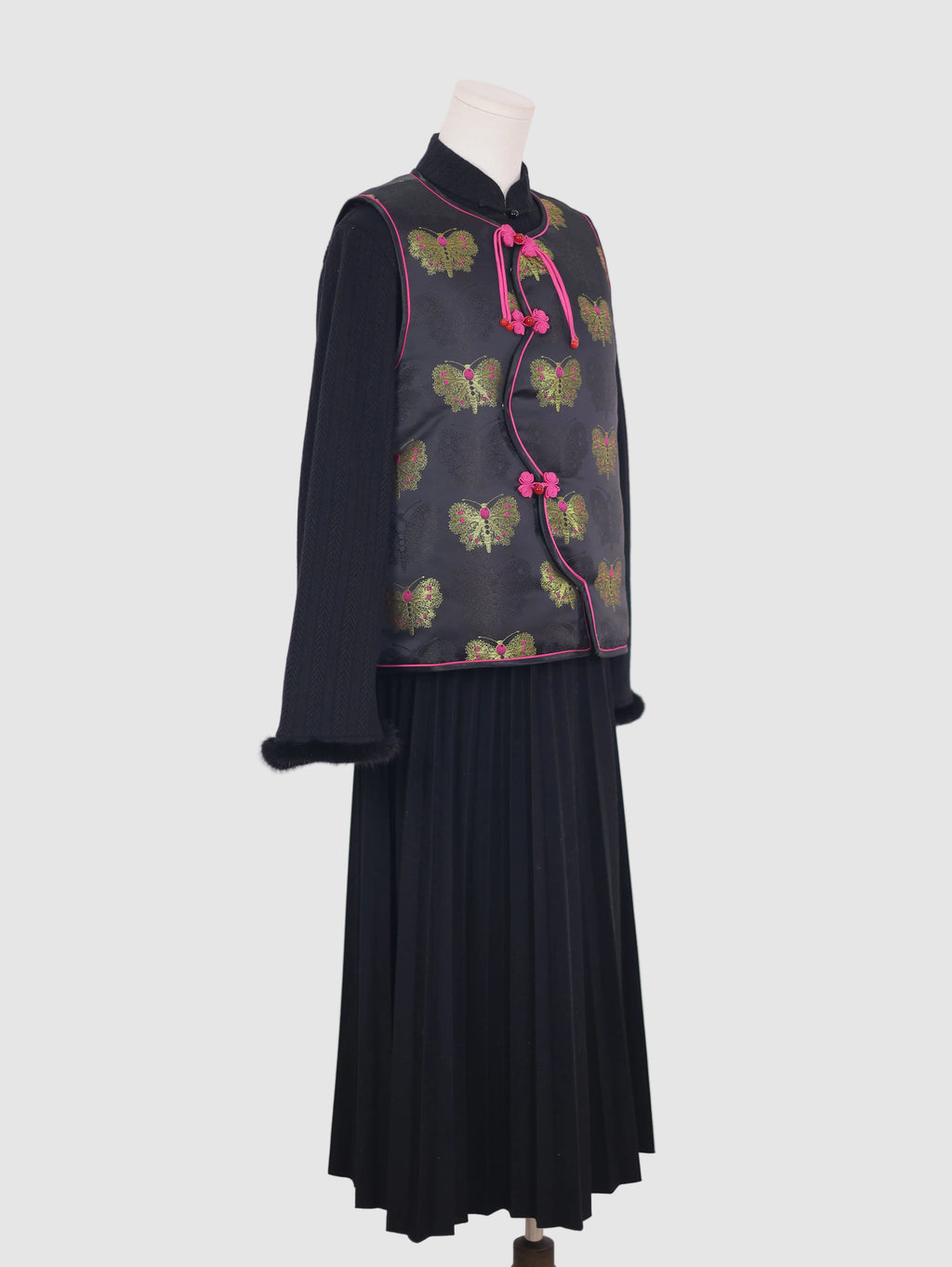 Side view of black butterfly jacquard vest with pink piping and curved wave-front closure
