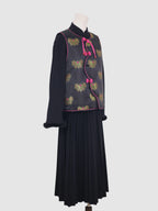 Side view of black butterfly jacquard vest with pink piping and curved wave-front closure