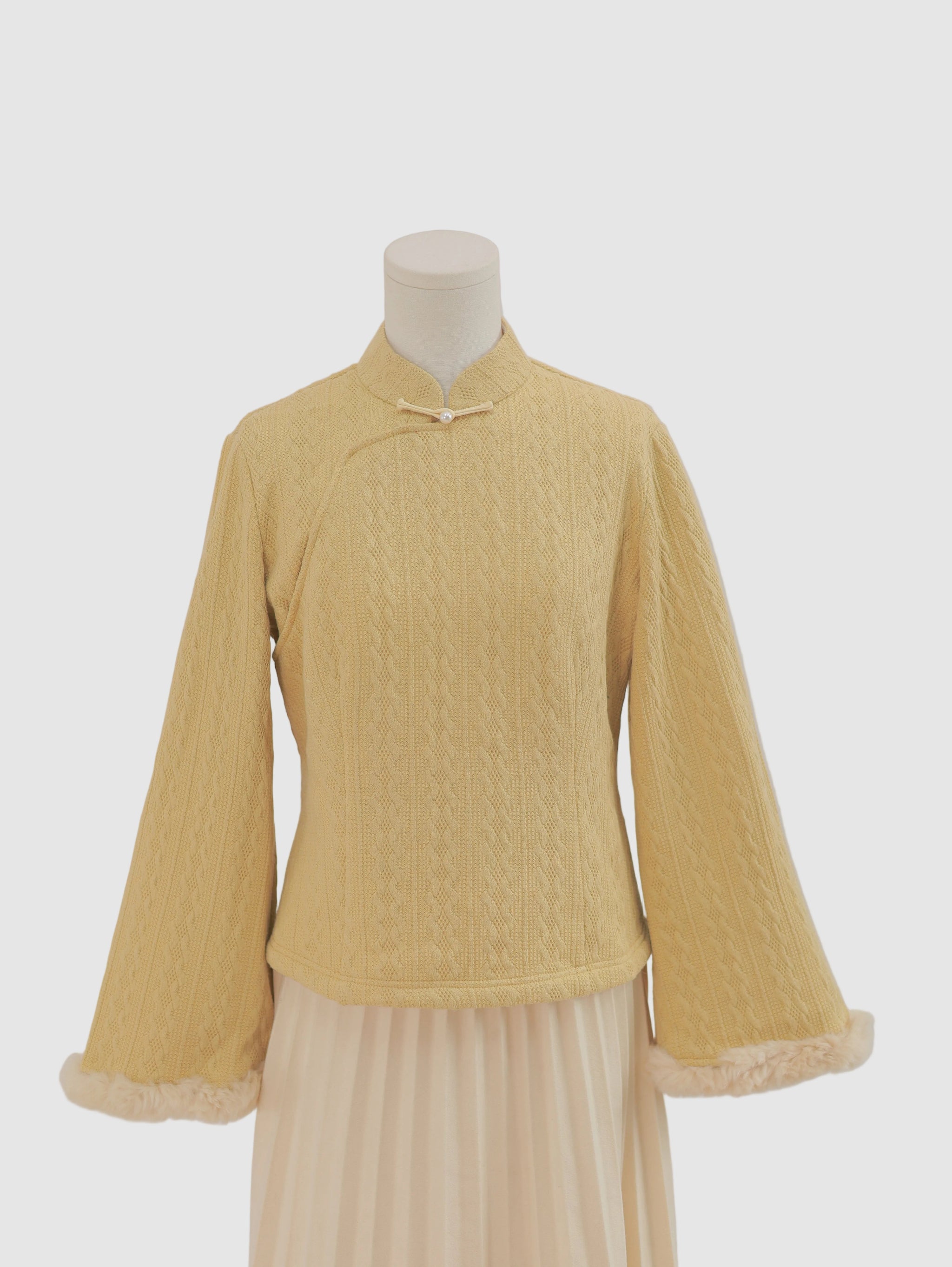 Wide-sleeve knitted fleece-lined base layer top with stand collar and frog button detail, front view