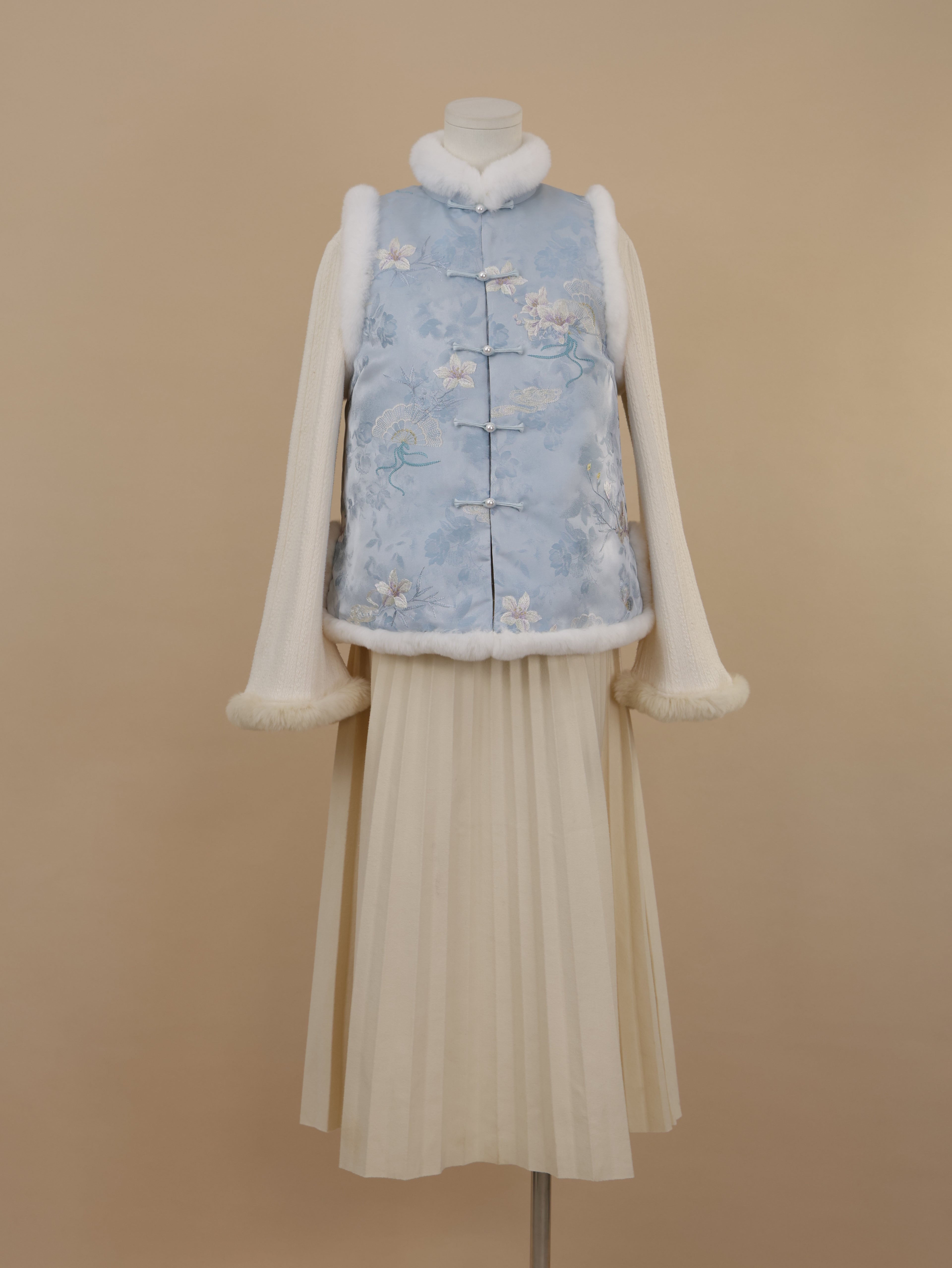 Misty blue embroidered vest with white rabbit fur trim and straight frog-button closure, front view.