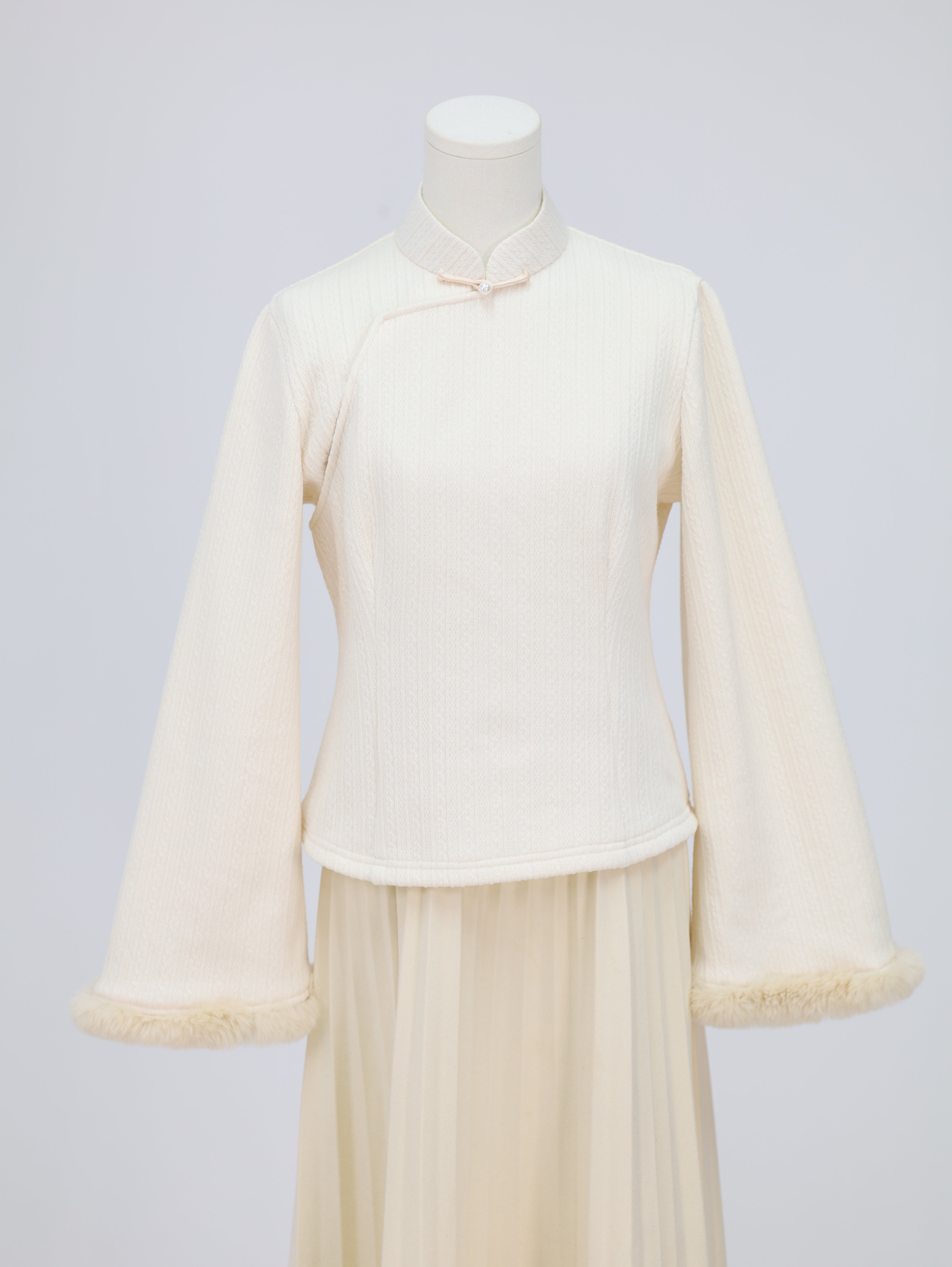 Wide-sleeve knitted fleece-lined base layer top with stand collar and frog button detail, front view