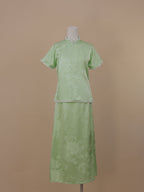 Full front view of pale green silk qipao set with jacquard floral pattern and mid-calf skirt