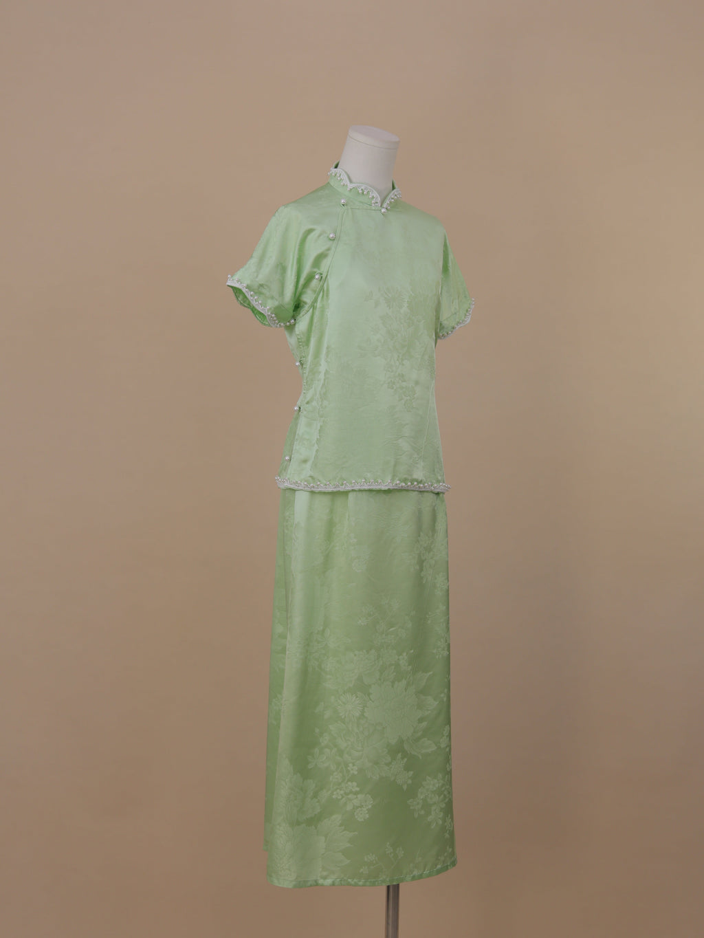 Side view of pale green silk qipao set showing traditional side fastening and elegant drape