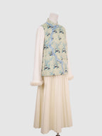 Side view of pastel green panda print vest with blue contrast piping