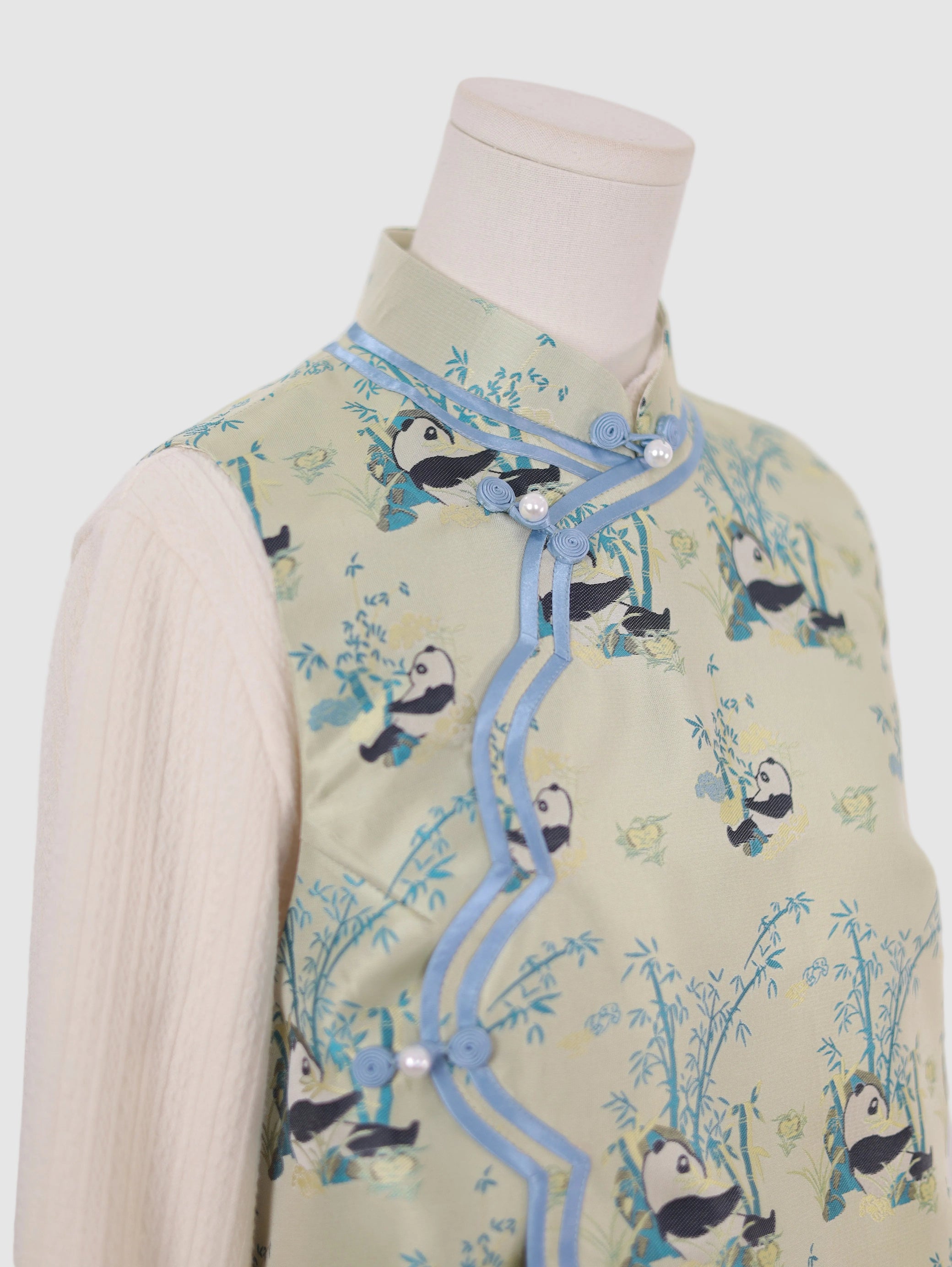 Detail of blue contrast piping along collar and front edge of panda vest