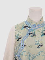 Close-up of frog button closure and curved wave-front design on panda print vest