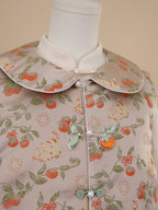 Close-up of persimmon and cat motif on beige vest