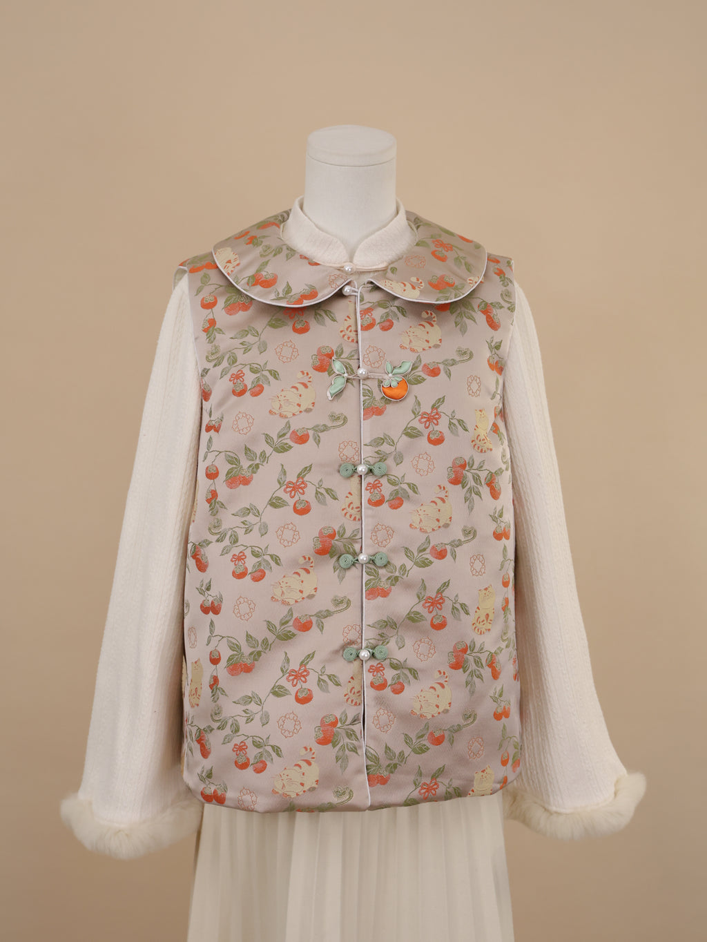 Half front view of beige vest with persimmon and cat print