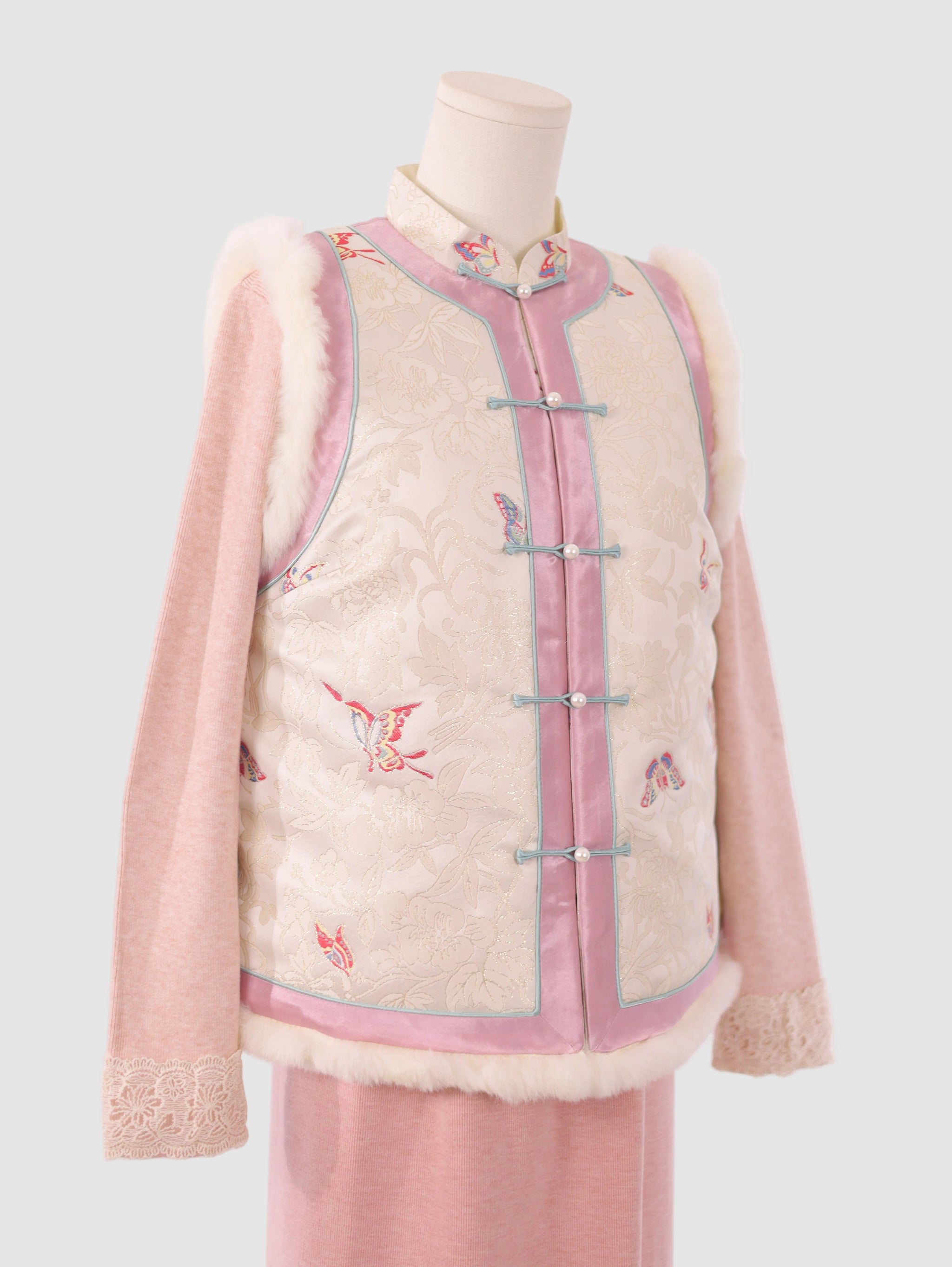 Side half view of pink and white butterfly jacquard vest showing silhouette and fur edging