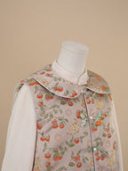 Close-up of rounded collar and frog button detail on persimmon print vest