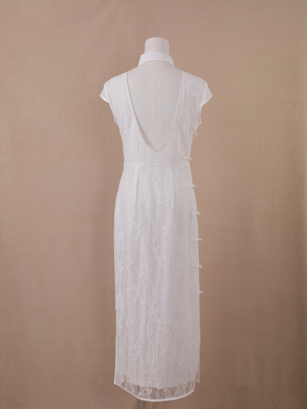 Full back view of white lace backless qipao cheongsam, ankle-length with deep V back and pearl details.