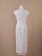 Full back view of white lace backless qipao cheongsam, ankle-length with deep V back and pearl details.