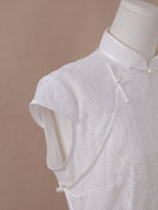 Shoulder and neckline detail of white lace qipao cheongsam, featuring intricate floral lace and pearl buttons.