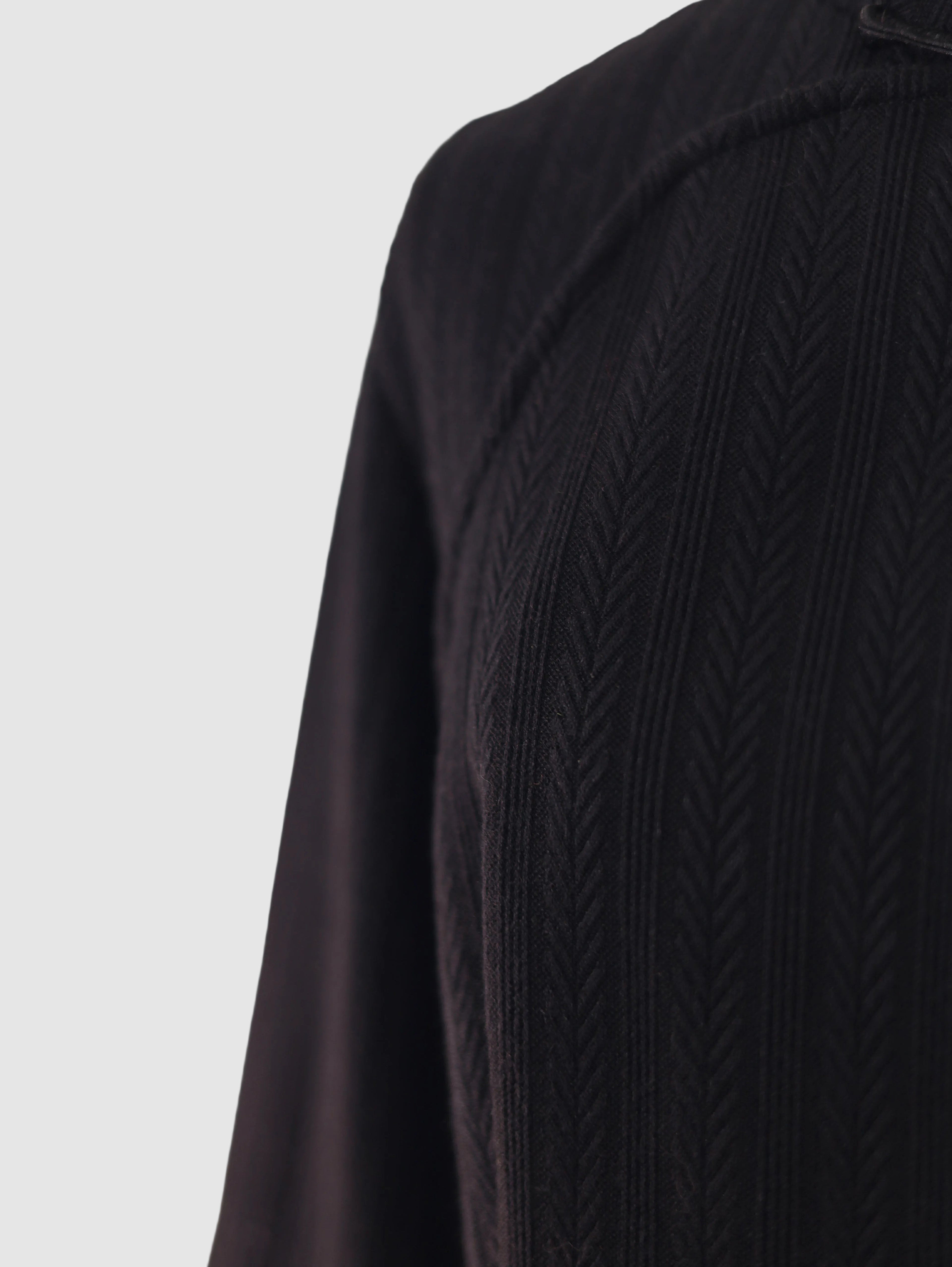 Close-up of stand collar with frog button detail on wide-sleeve knitted fleece-lined base layer top